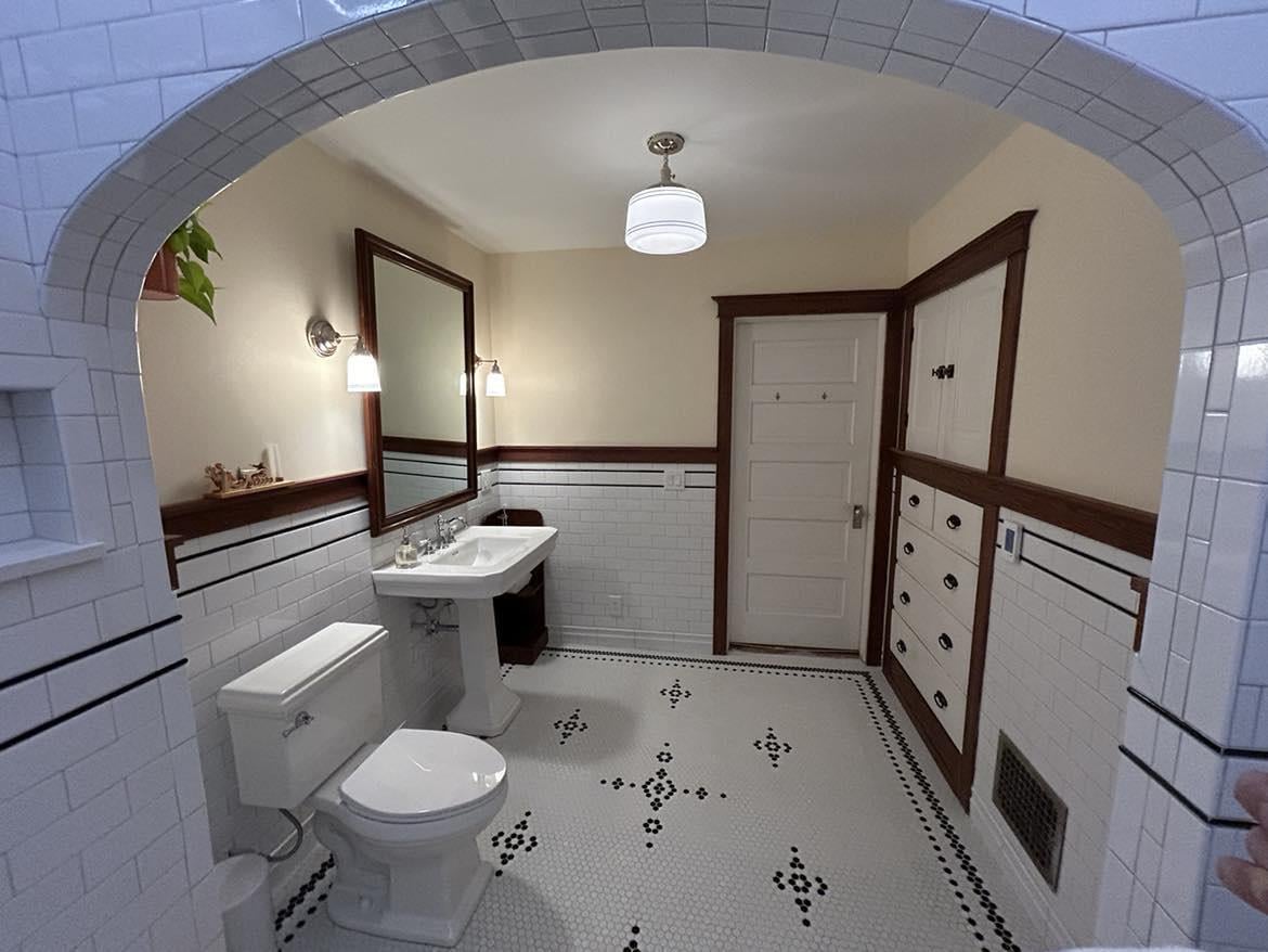 A bright renewed bathroom with double vanity, new lighting, and a safer layout.